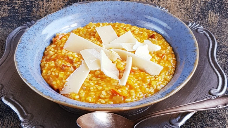 Hot Italian pumpkin risotto with Parmesan cheese shavings.