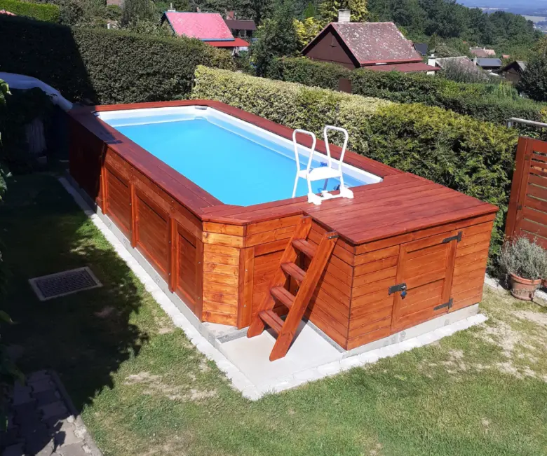 Hotový nadzemní bazén s dřevěným obkladem v zahradě.