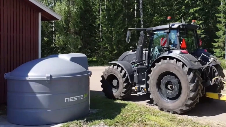 Traktor u nádrže na biopalivo značky Neste.