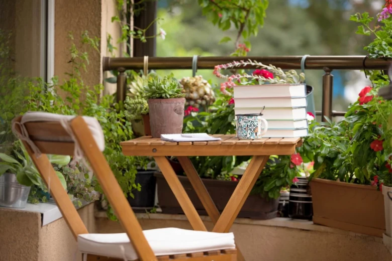 Malý balkon s rostlinami a dřevěným stolem pro inspiraci.