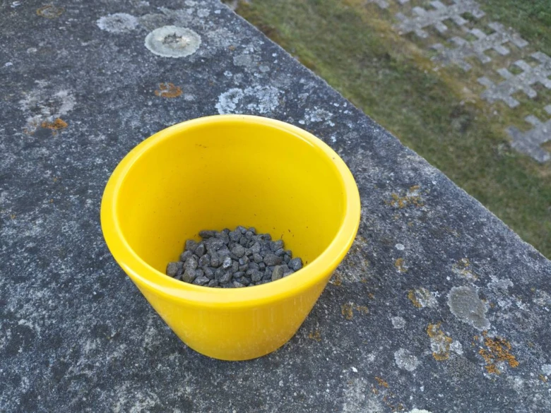 Žlutý hrnec s kameny pro drenáž do květináče