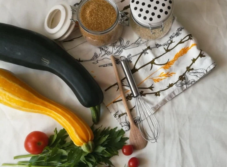 Žlutá a zelená cuketa s kuchyňskými nástroji na recept.