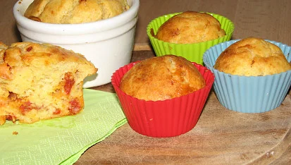 Bezlepkové muffiny a kousek buchty na dřevěném povrchu.