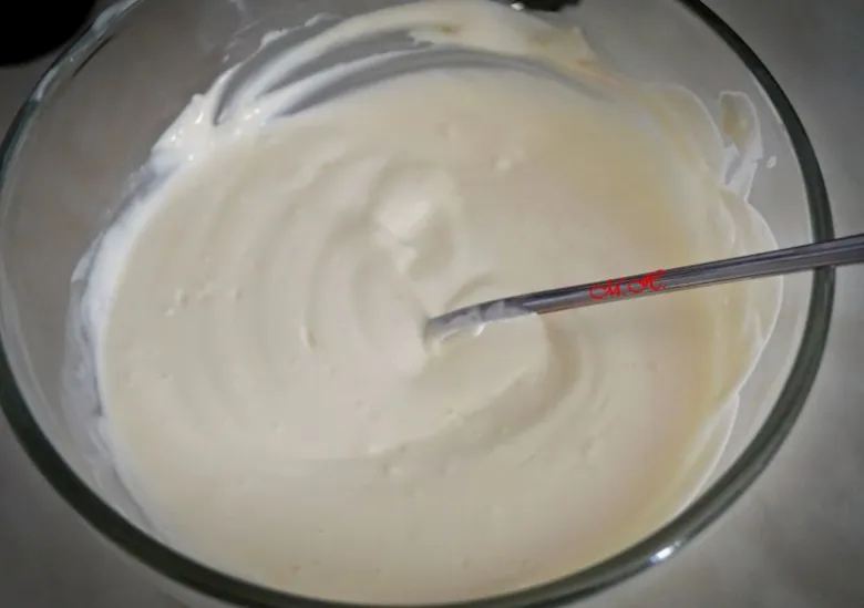 Bílá zálivka na těstovinový salát ve skleněné mísce s lžící