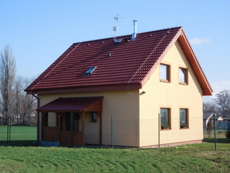Dokončená dřevostavba na zelené louce.