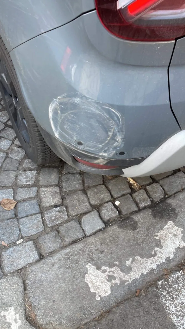 Škrábnutí na zadním nárazníku šedého auta.