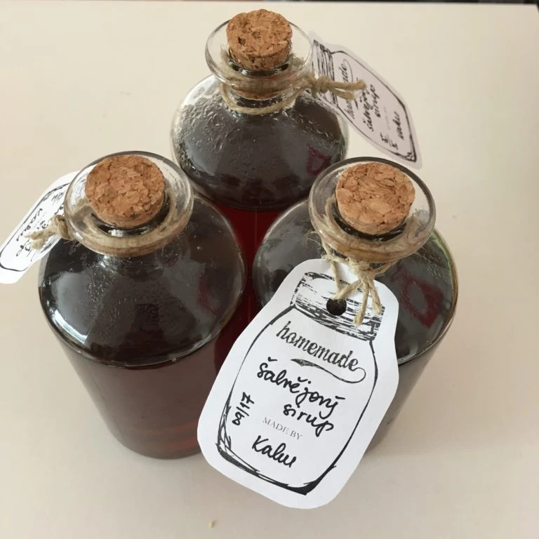 Domácí šalvějový sirup v lahvičkách s korkovými zátkami.