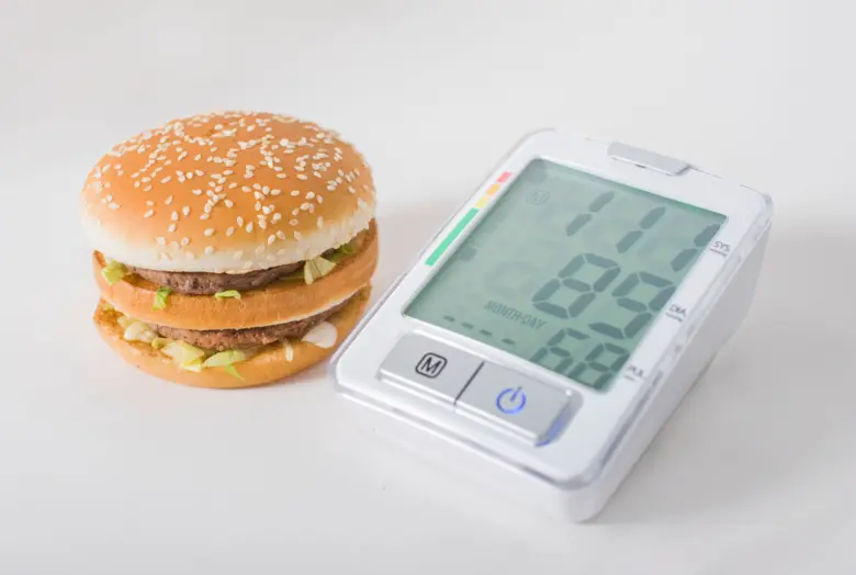 Burger vedle měřiče krevního tlaku pro téma přírodního snižování.
