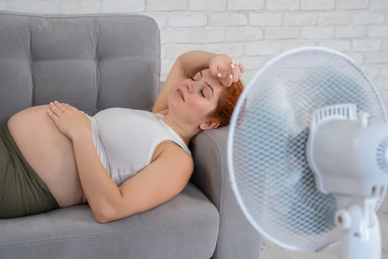 Těhotná žena s ventilátorem kvůli pocení v noci