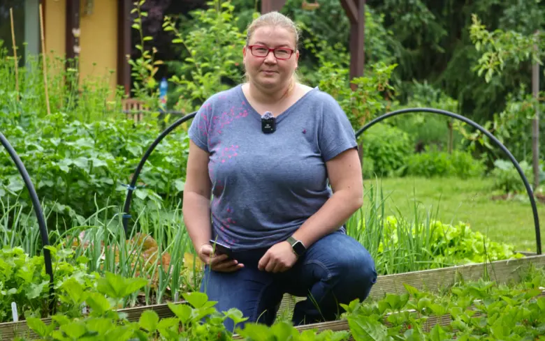 Žena v zahradě s rostlinami po česneku