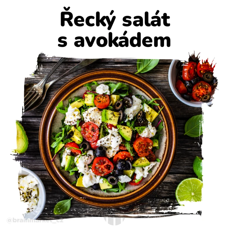 Řecký salát s avokádem v hrnci na dřevěném stole.