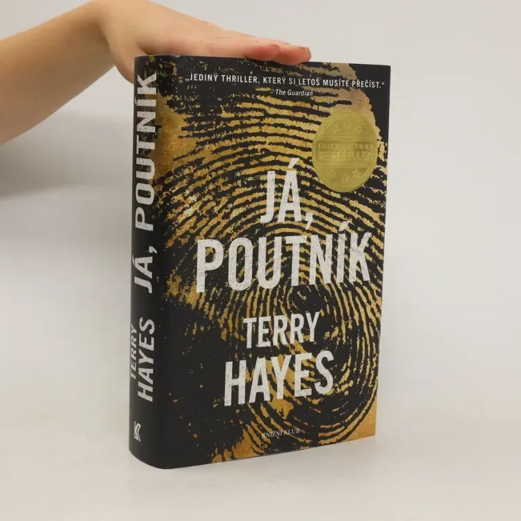 Ruka drží knihu detektivní fikce Já, poutník od TERRY HAYES.